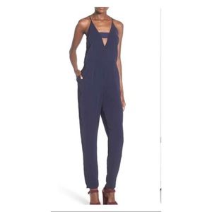 Navy jumpsuit by Stored.  Size S.  Keyhole cut out and halter neck & pockets.